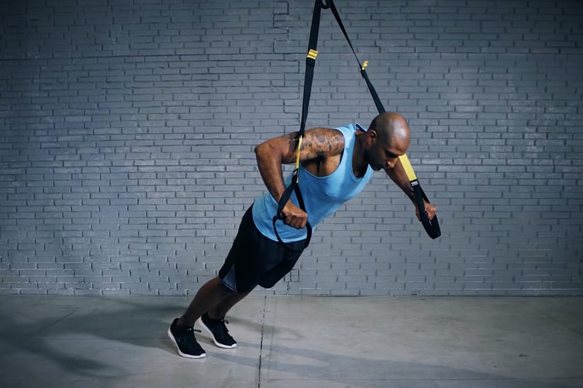 Man doing chest press with TRX