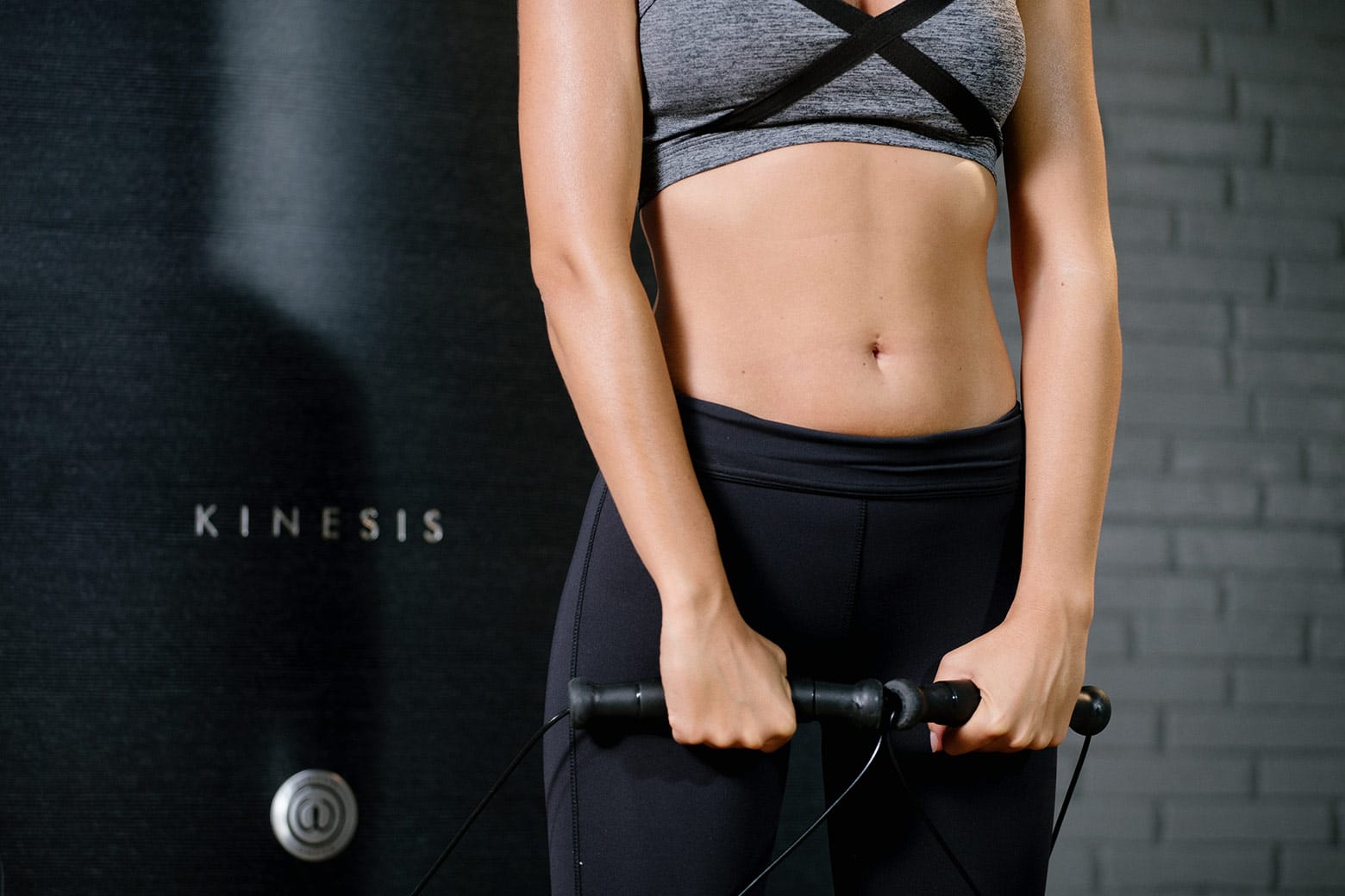 Woman working out with the Kinesis wall.